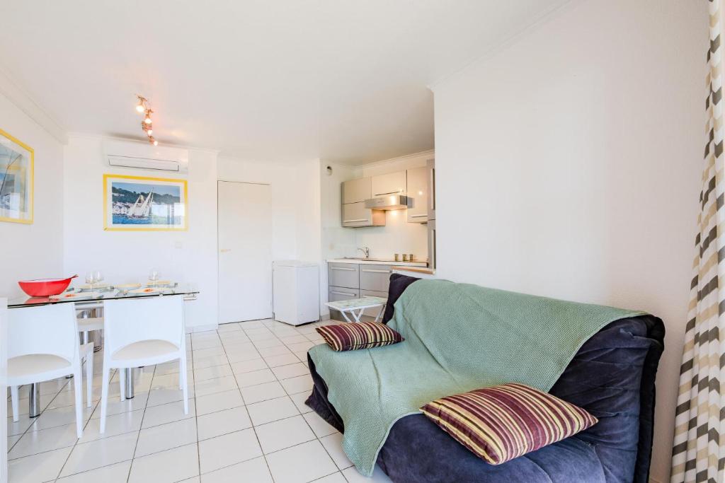 un salon avec un canapé et une cuisine dans l'établissement Résidence le Hameau de Cap Esterel - maeva Home - Appartement 2 pièces 4 personnes - Prestige MAE-6441, à Saint-Raphaël