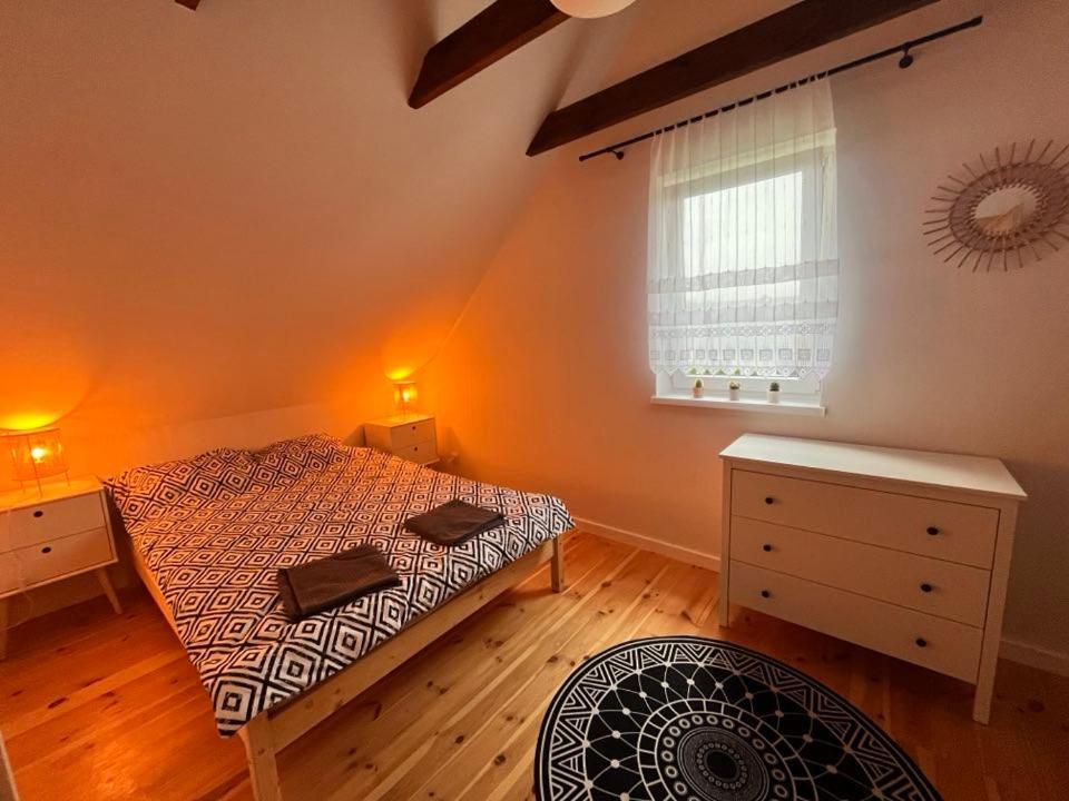 a bedroom with a bed and a window at Letnia Ostoja Wieprz nad Jeziorakiem in Zalewo