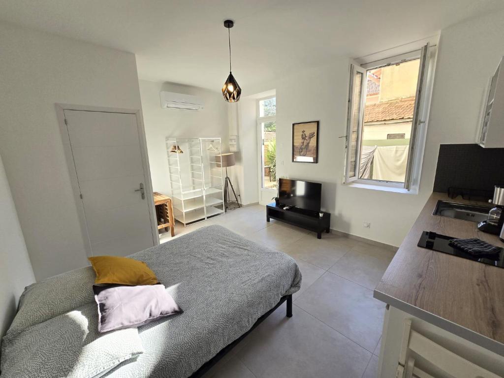 une chambre avec un lit, un bureau et une fenêtre dans l'établissement GregBnb - Studio 23m2 - Climatisé -10min Gare - 5, à Toulon