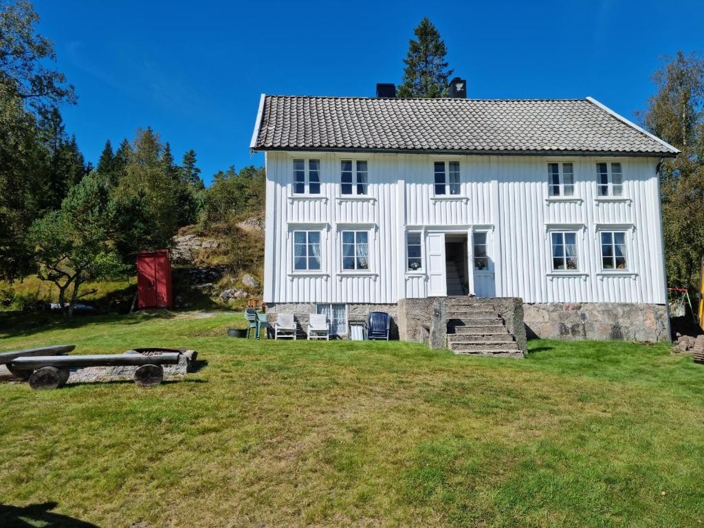 ein großes weißes Haus auf einem Grasfeld in der Unterkunft Flott hytte Bjelland Lindesnes in Bjerland