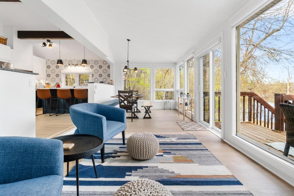 a living room with a blue chair and a table at The Cozy Woodpecker Cottage in Notre-Dame-de-l'Île-Perrot