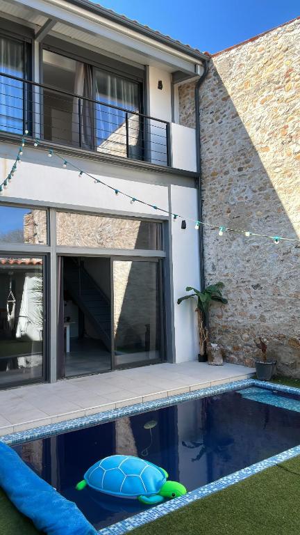 une maison avec une piscine devant une maison dans l'établissement Experience intime, à Torreilles