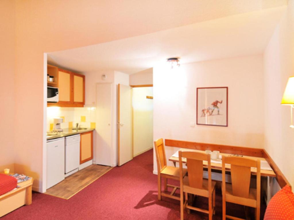 une cuisine et une salle à manger avec une table et des chaises dans l'établissement Résidence Le Carrousel - Studio fonctionnel · Skis aux pieds · Vue vallée MAE-3739, à Les Coches