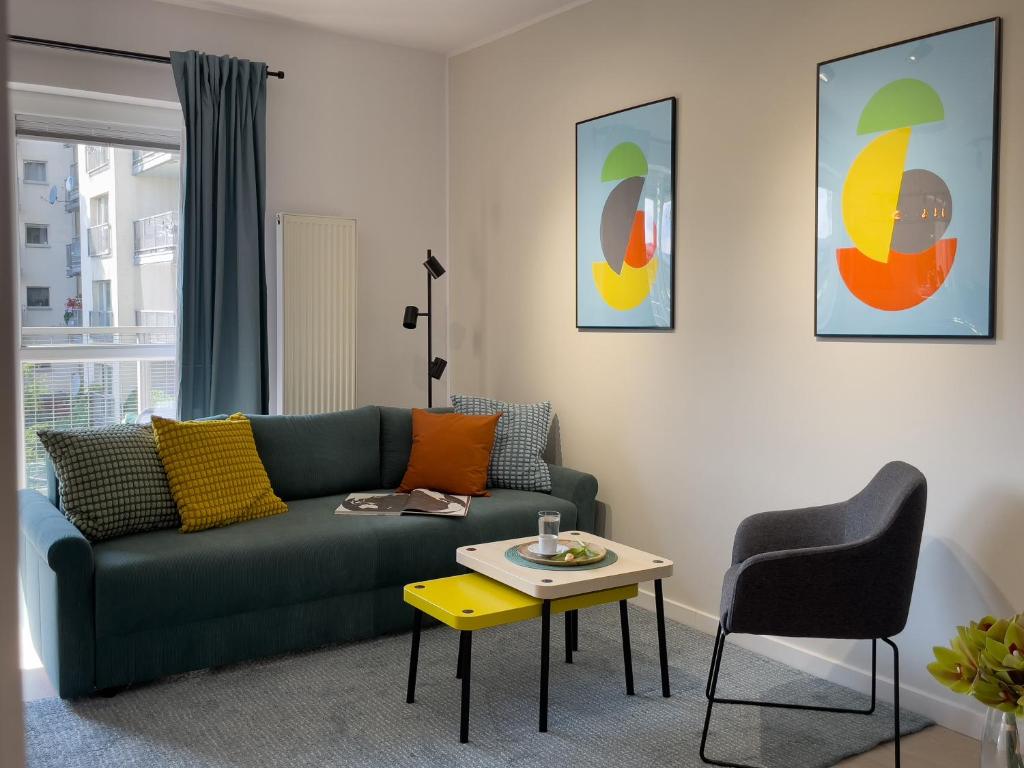 a living room with a green couch and a table at URBAN APARTMENTS PREMIUM Baildona No 11 FREE GARAGE, Self CHECK-IN in Katowice