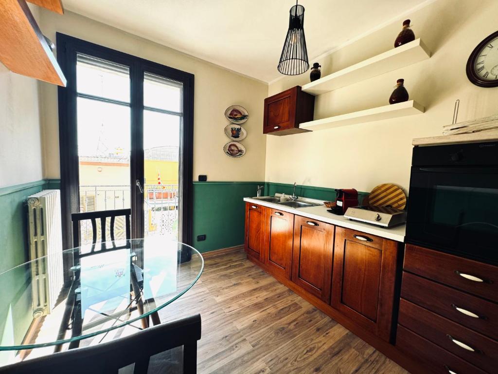 a kitchen with a glass table and a large window at Casa dello Chef, Il loft nel cuore della città in Lecce