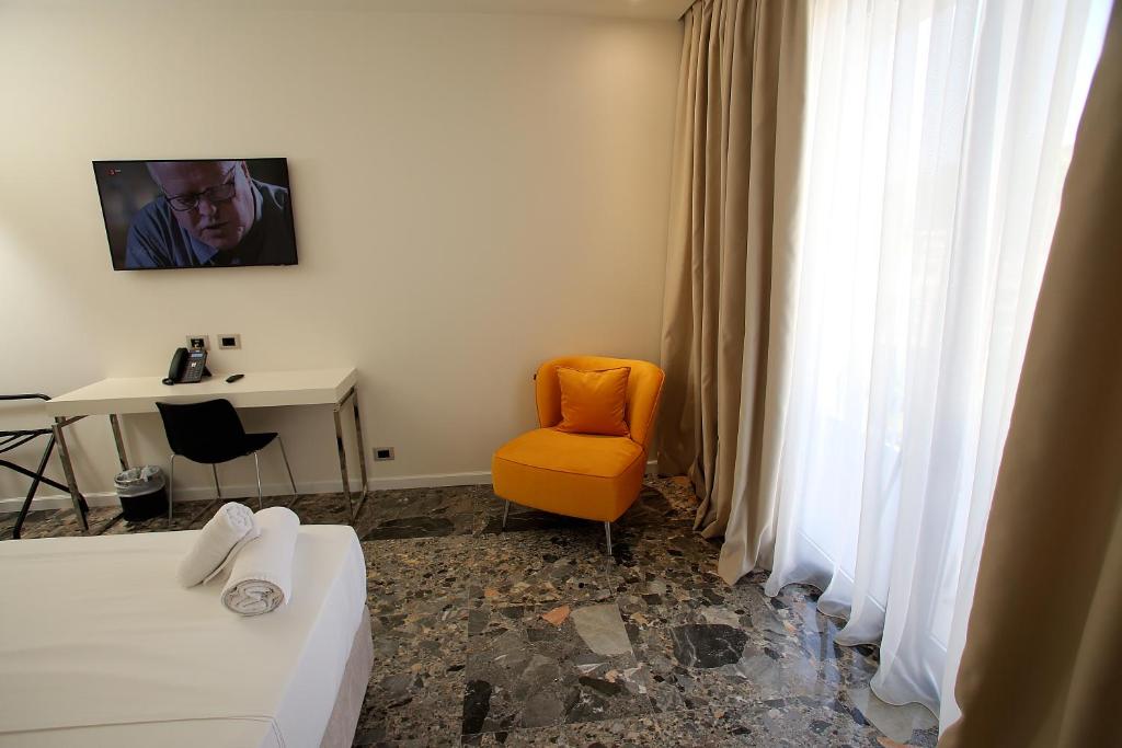 Camera con letto, sedia e scrivania. di Durres Bay Hotel a Durrës