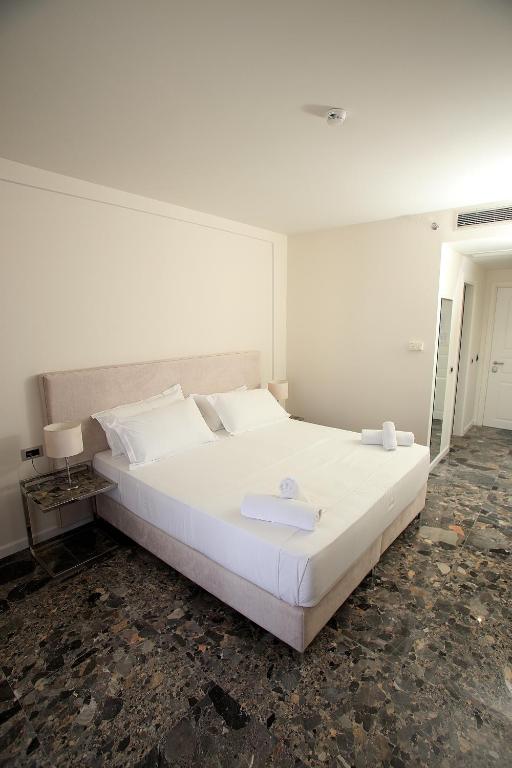 una camera da letto con un grande letto bianco in una stanza di Durres Bay Hotel a Durrës