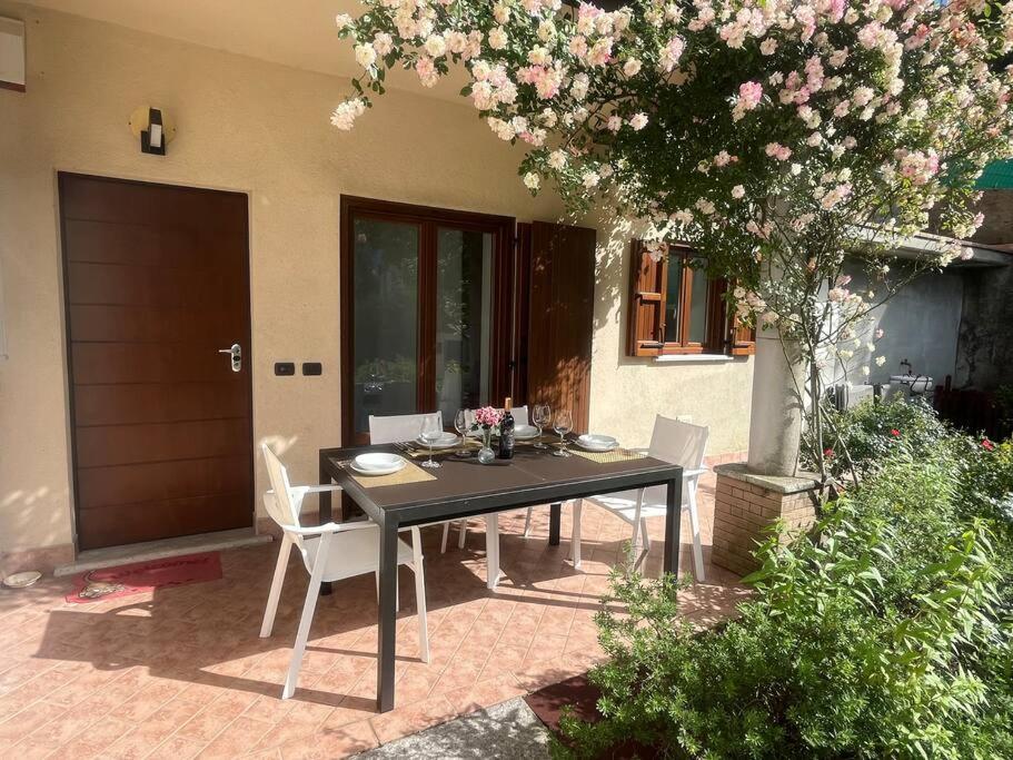 Una mesa y sillas en un patio con un árbol. en casa Angelica Germignaga, en Germignaga