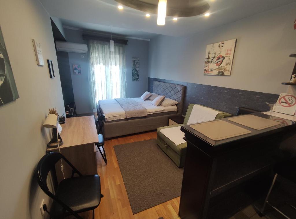 Una pequeña habitación con una cama y un escritorio. en Pg Apartment, en Podgorica