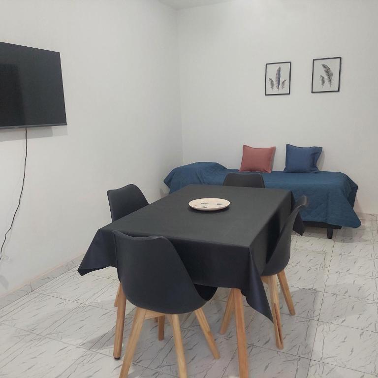a room with a table and chairs and a bed at Departamentos Falucho 3 in Santa Rosa