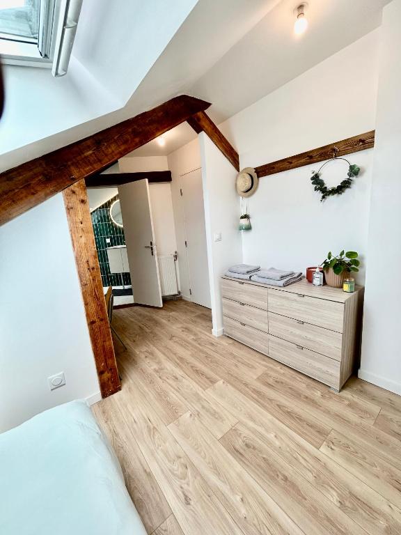 - une chambre avec des murs blancs et des poutres en bois dans l'établissement Le Victor, à Coulommiers