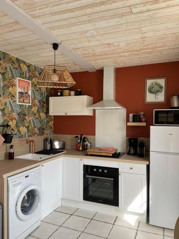 a kitchen with white cabinets and a washer at Terrama de l'isle in LʼIsle-sur-la-Sorgue