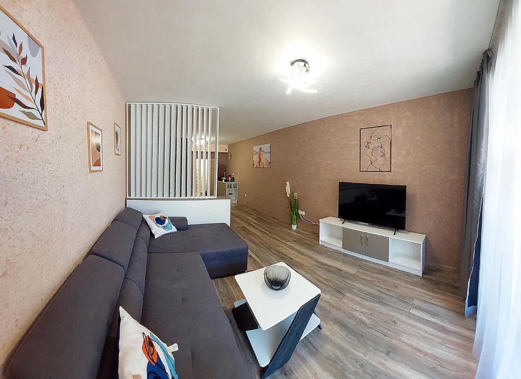 a living room with a couch and a flat screen tv at Art Sense Мезонет in Shkorpilovtsi