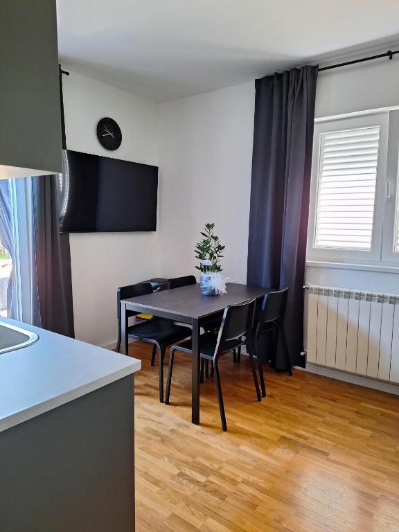 a dining room with a table and chairs in a kitchen at Apartment Vidak in Labin
