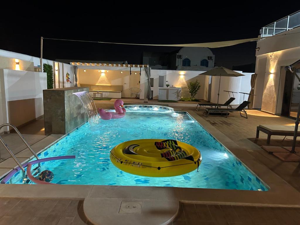 a large swimming pool with a banana boat in it at Grande Villa Familiale Route Du Phare in Djerba