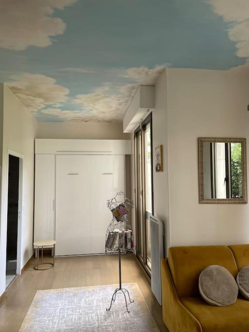 - un salon avec un canapé et un plafond dans l'établissement Studio cadre bucolique Neuilly Paris, à Neuilly-sur-Seine