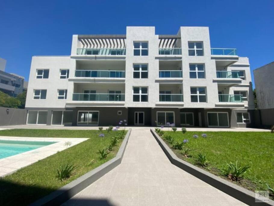 een groot wit gebouw met een zwembad ervoor bij Moderno 2 Ambientes con cochera in Tandil