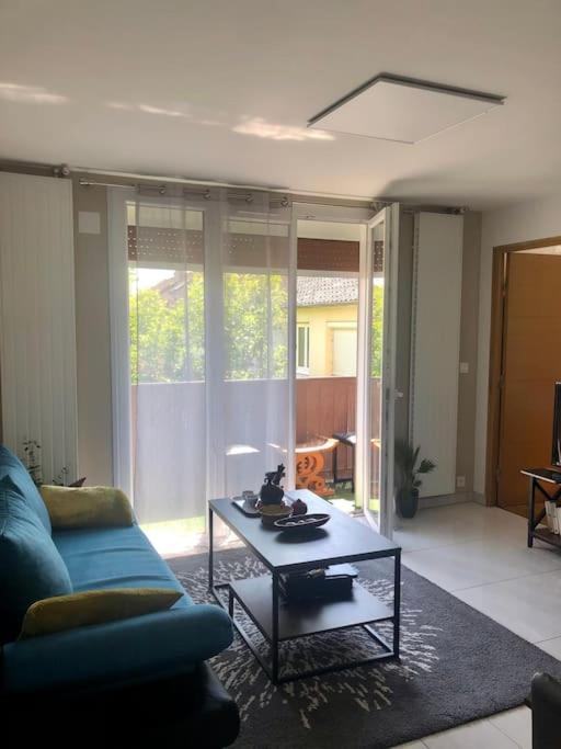 un salon avec un canapé bleu et une table basse dans l'établissement Appartement 2 chambres à Massy TGV, à Massy