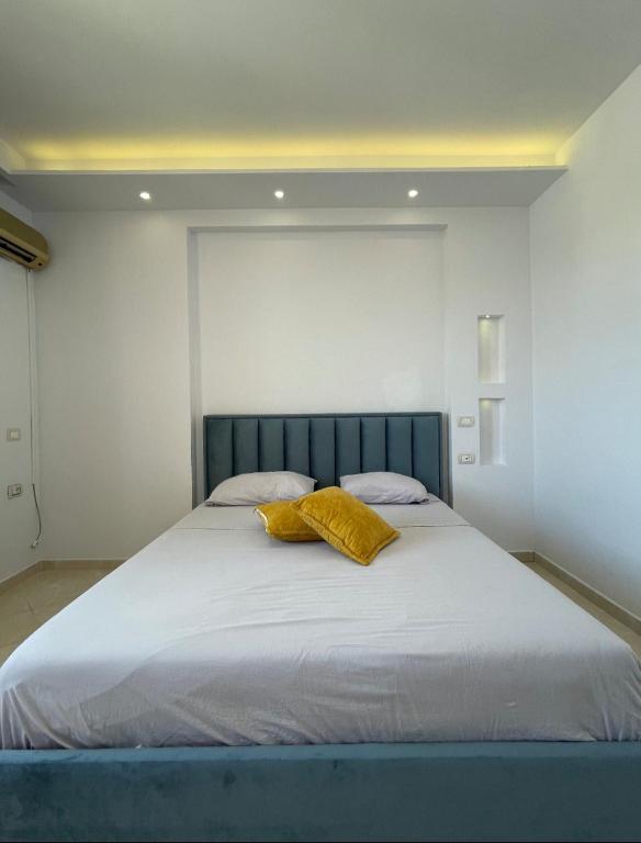 ヴロラにあるPerla Marina Houseの黄色い枕が置かれた大きなベッドのある寝室