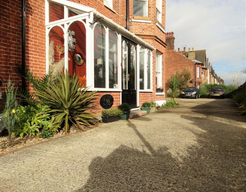 a brick house with a shadow on the street at The Corner House in Lowestoft