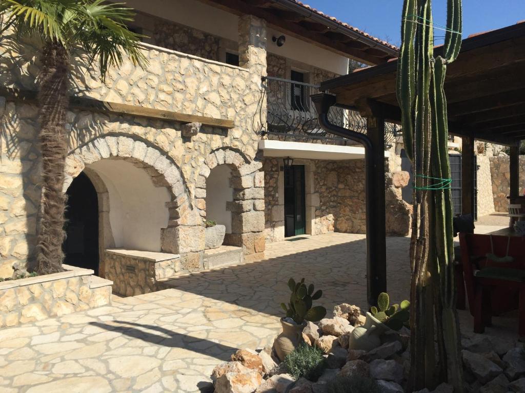 a stone building with a palm tree in front of it at Family friendly house with a swimming pool Bribir, Novi Vinodolski - 23474 in Bribir