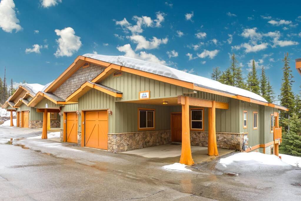 un edificio verde con nieve encima en Best Ski-in out 3 Bdrm Chalet, with Hot Tub, en Big White