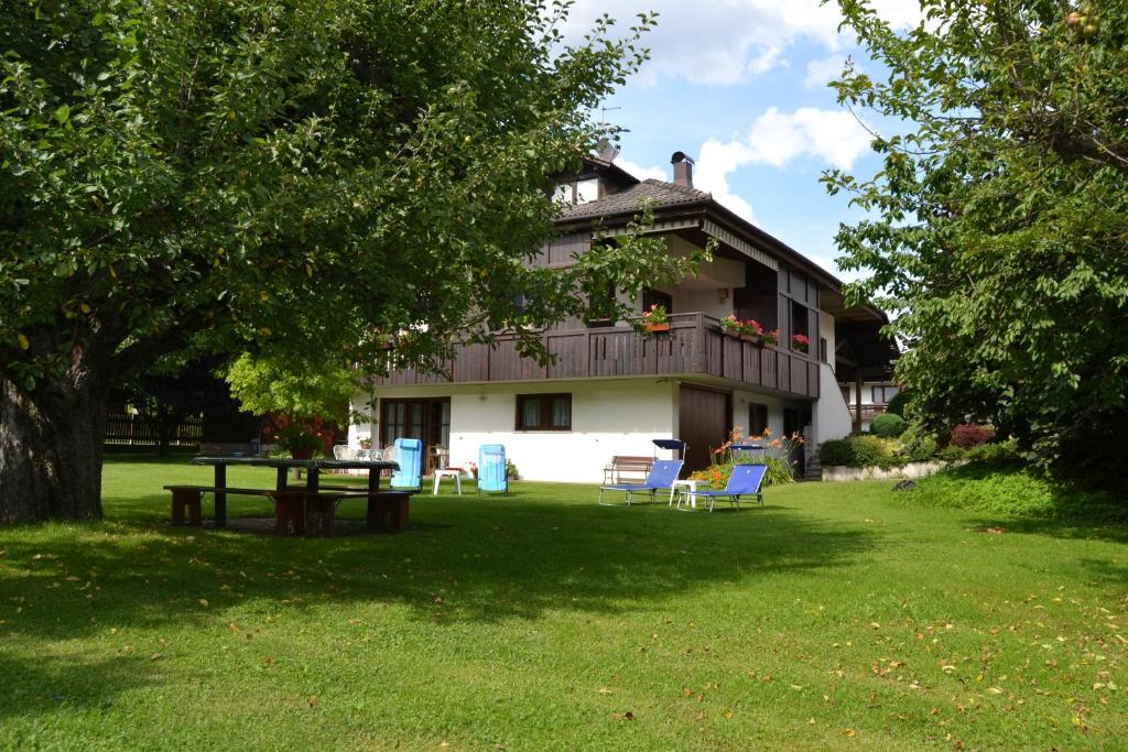 a house with a table and chairs in the yard at Dimaro Folgarida Appartamento trilocale in villa in Monclassico