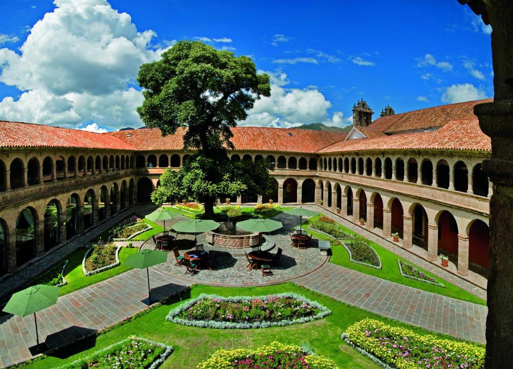 a courtyard in a building with a tree in the middle at Monasterio, A Belmond Hotel, Cusco in Cusco