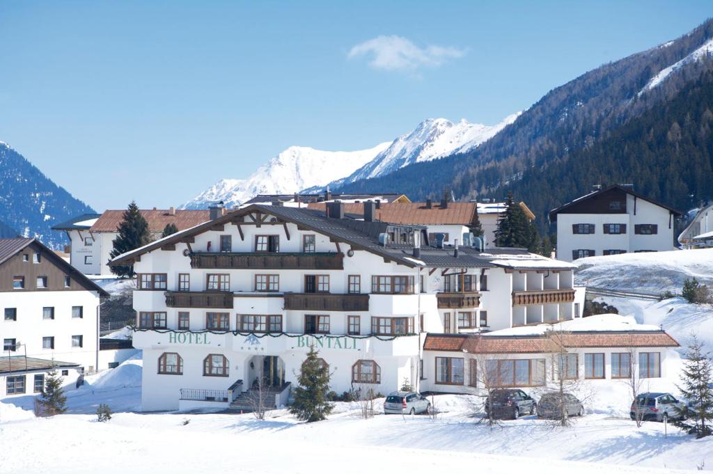 un grupo de edificios en la nieve con montañas en Hotel Büntali, en Galtür