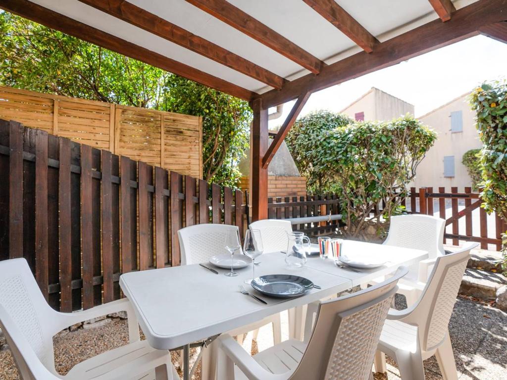 une table blanche et des chaises sur une terrasse dans l'établissement Pavillon Climatisé avec Mezzanine, Piscine et Parking Privé à St Pierre la Mer - FR-1-409A-32, à Fleury