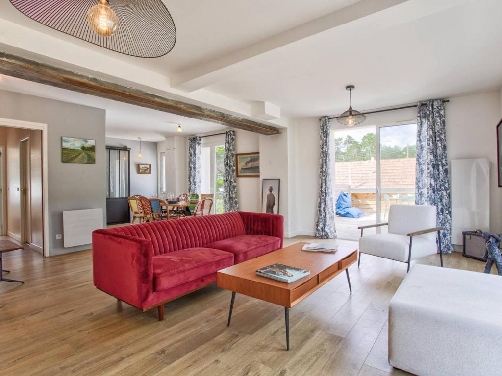 un salon avec un canapé rouge et une table dans l'établissement Maison de Charme à Merville-Franceville-Plage, 10 Pers, Proche Mer, Grande Terrasse et Studio Indépendant - FR-1-788-27, à Merville-Franceville-Plage