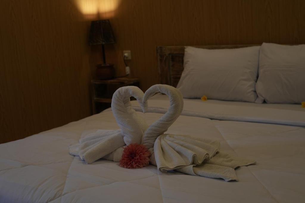two swans made out of towels on a bed at Ambara Guest House in Tampaksiring