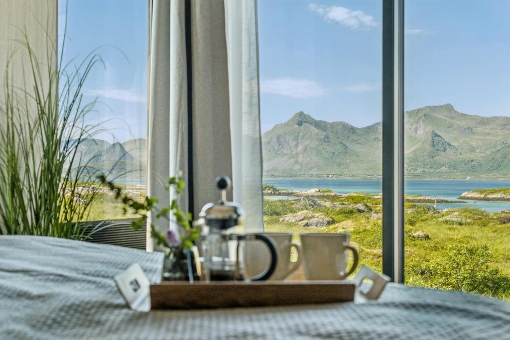 a bed with a view of the mountains at Luxury Cabin in beautiful Lofoten with Jacuzzi and sauna in Kleppstad