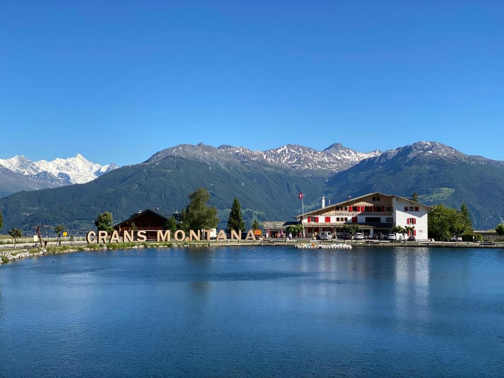 Una vista de un lago con montañas al fondo. en Hotel du Lac, en Crans-Montana