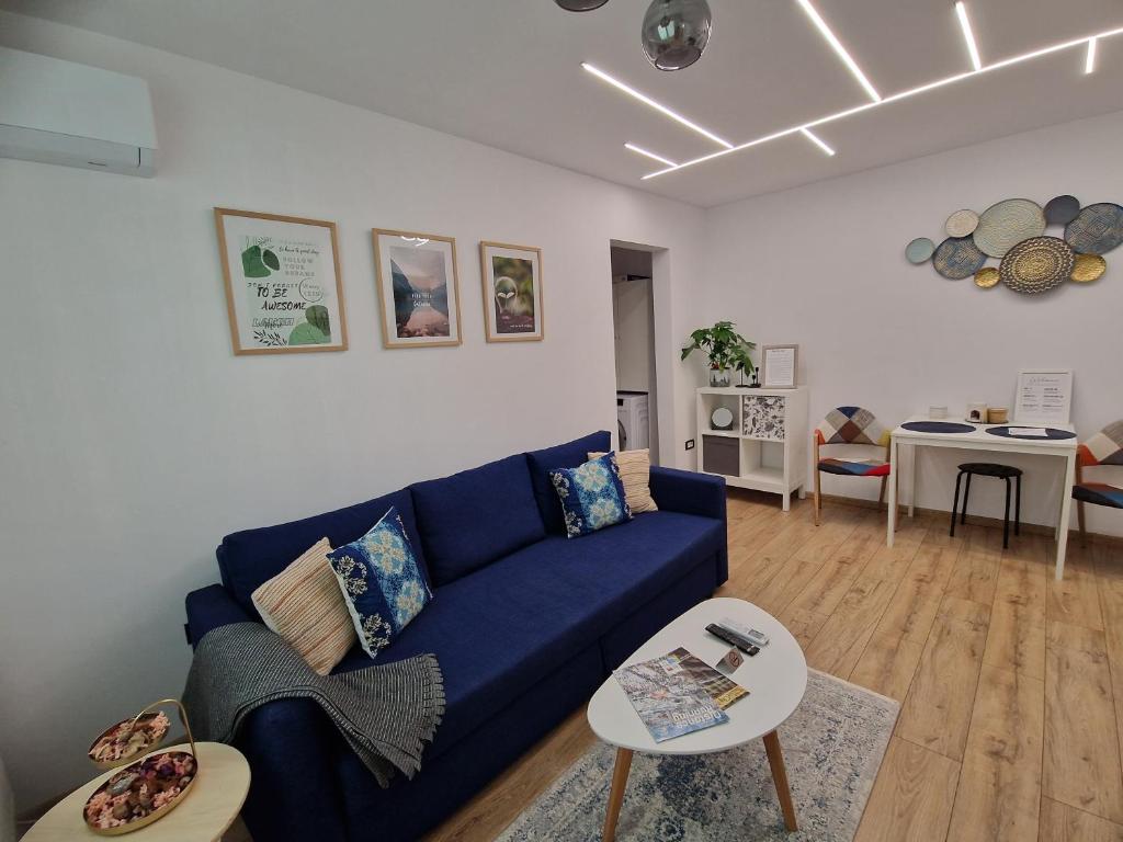 克卢日-纳波卡BRB Park Studio的客厅里有一张蓝色的沙发和一张桌子