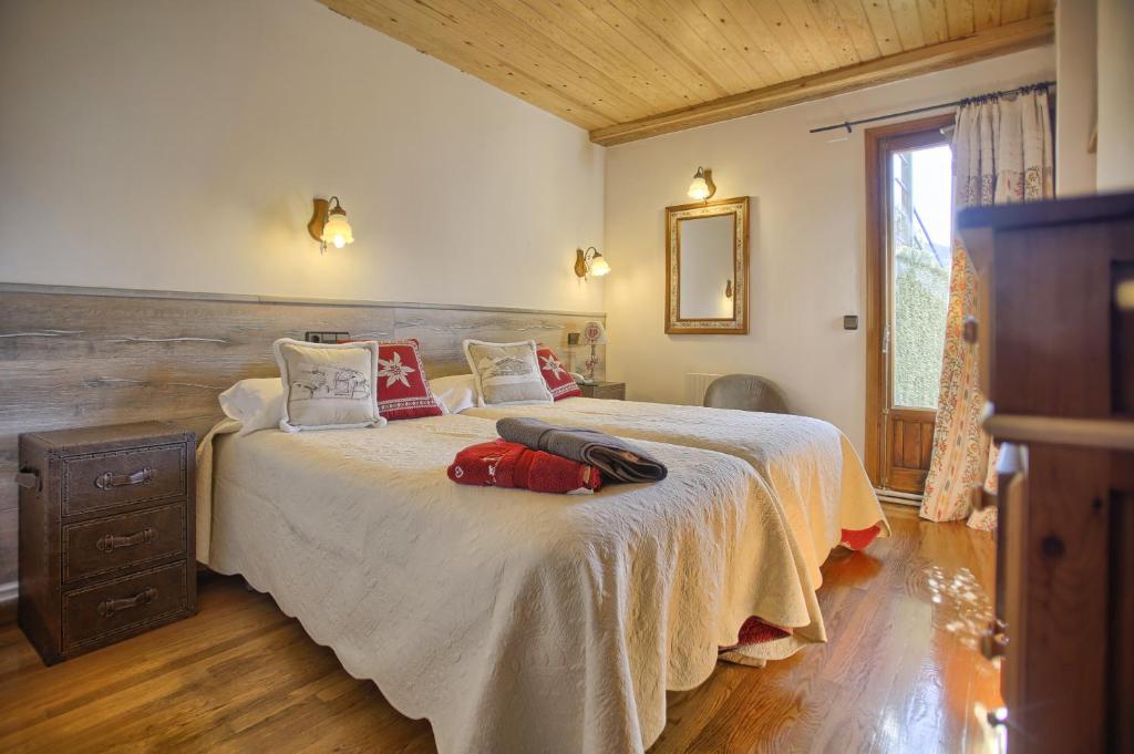 1 dormitorio con 1 cama grande con almohadas rojas en San Marsial Benasque Apart Hotel, en Benasque