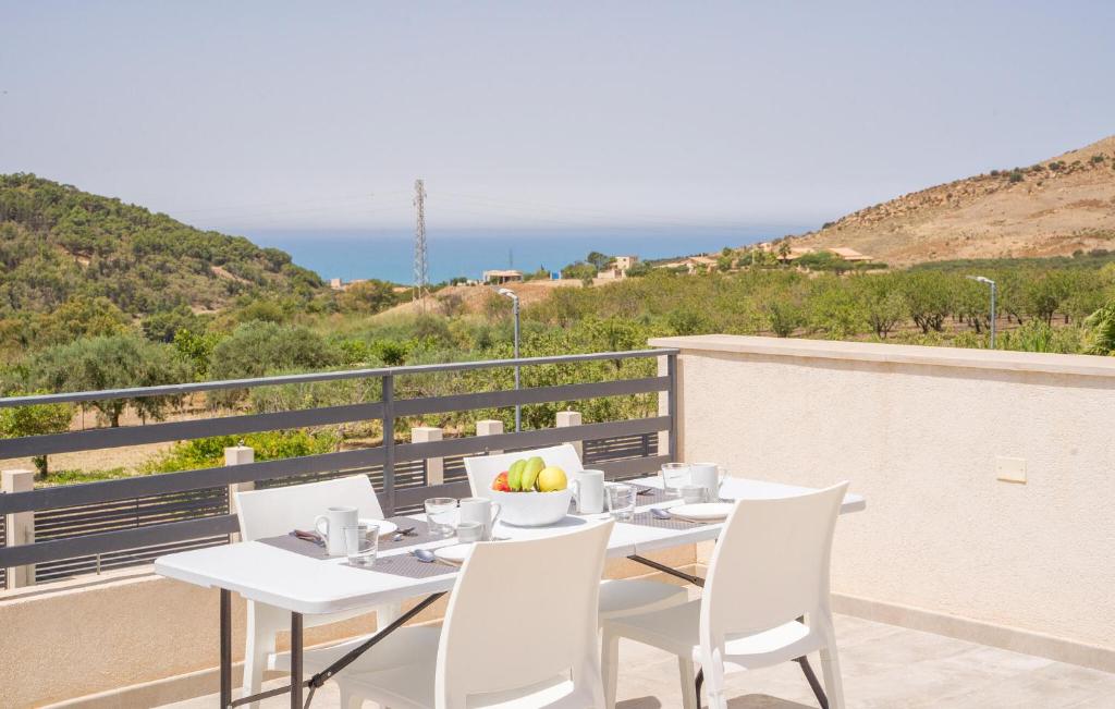 a white table and chairs on a balcony with the ocean at Gorgeous Home In Realmonte With Kitchen in Realmonte