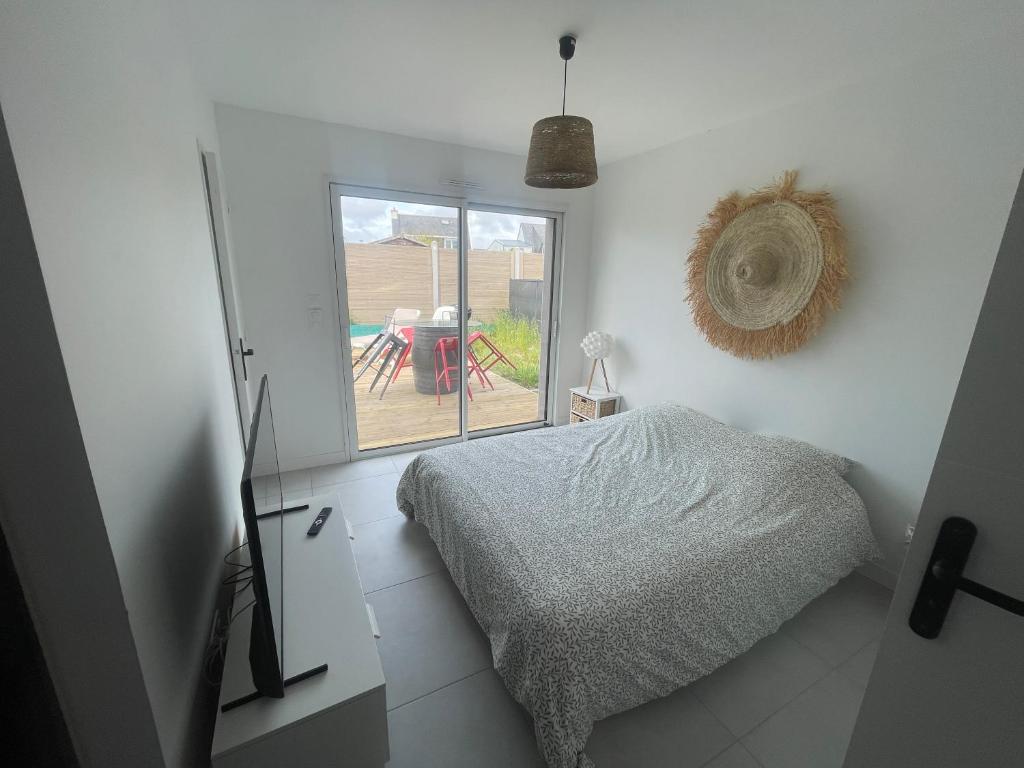 a bedroom with a bed and a view of a patio at Maison 5 chambres sortie saint malo in Saint-Méloir-des-Ondes