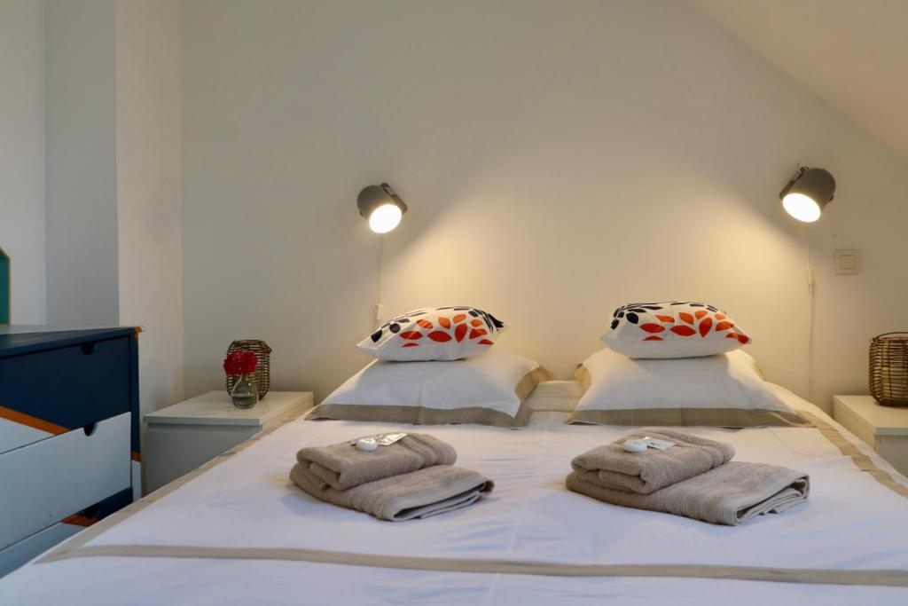 Un dormitorio con una cama con toallas. en Petit appartement calme vue sur havre de Carteret, en Barneville-Carteret
