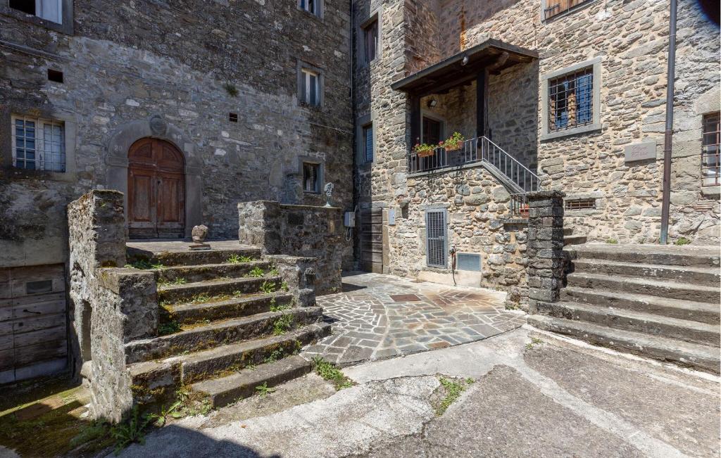 stary kamienny budynek ze schodami i drzwiami w obiekcie Nice Home In Nicciano With Jacuzzi w mieście Piazza al Serchio
