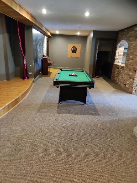a pool table in the middle of a room at Forest apartment in the loop of the river Neris in Verkšonys