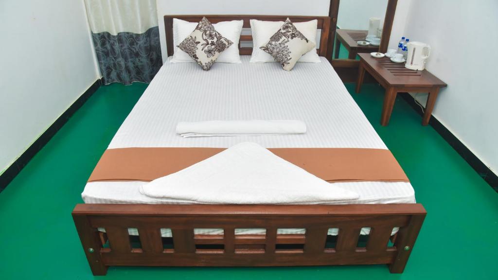 a bedroom with a wooden bed with white and brown at Elite Home Stay in Dambulla