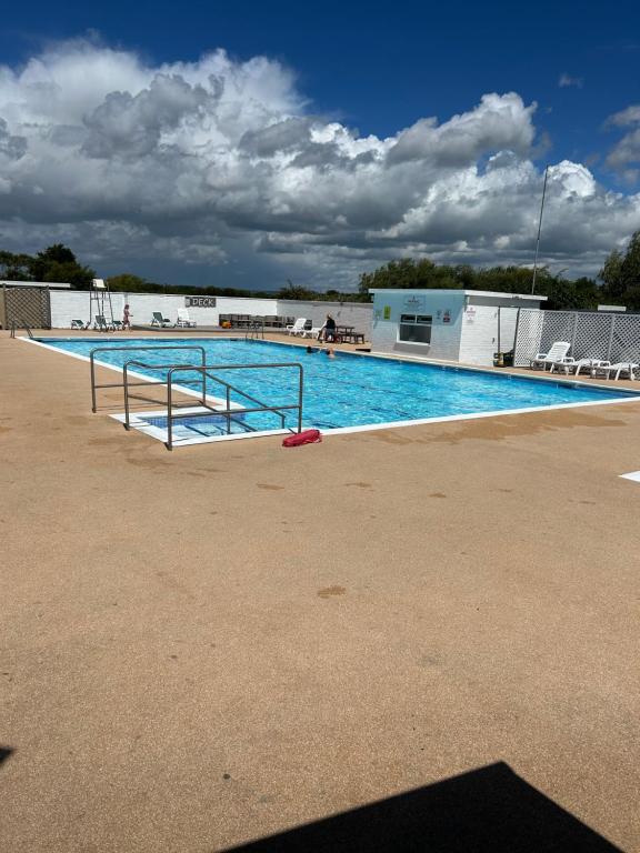 a large swimming pool with blue water at Little Spain in Selsey