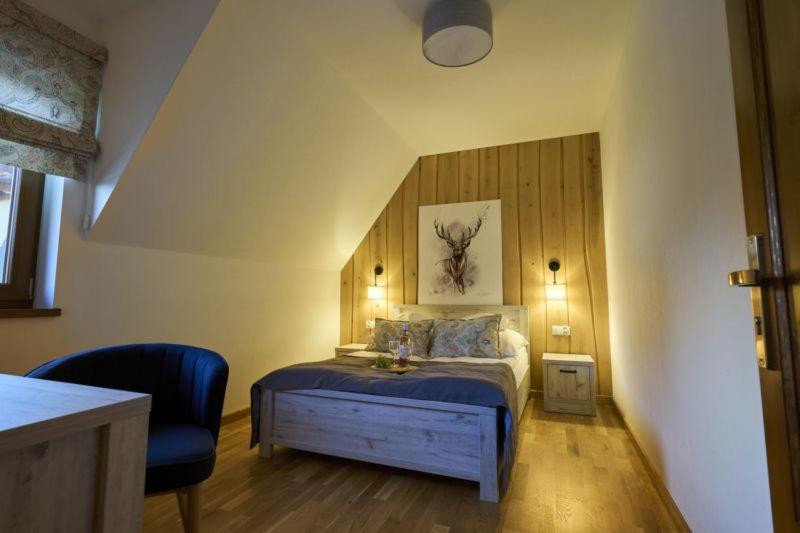 une chambre avec un lit et une chaise bleue dans l'établissement Apartament Kohutówka, à Bukowina Tatrzańska