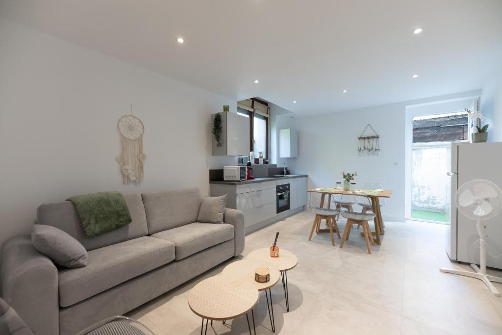 un salon avec un canapé et une table dans l'établissement Appartement entièrement neuf avec terrasse privative !, à Mulhouse