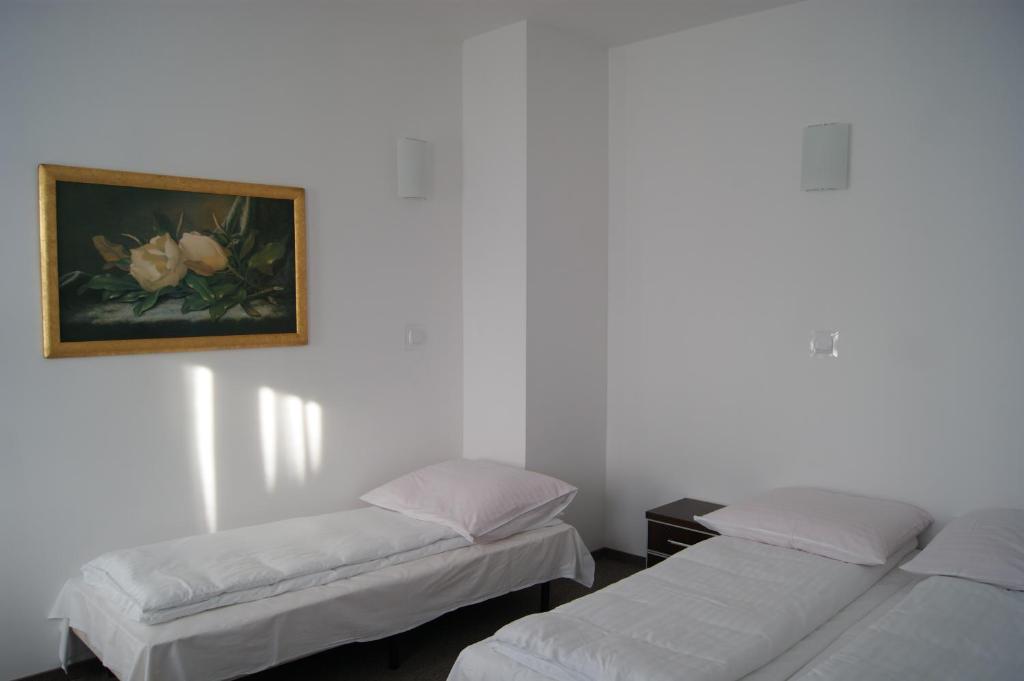 a room with two beds and a painting on the wall at Dom Wczasowy Zefir in Świnoujście