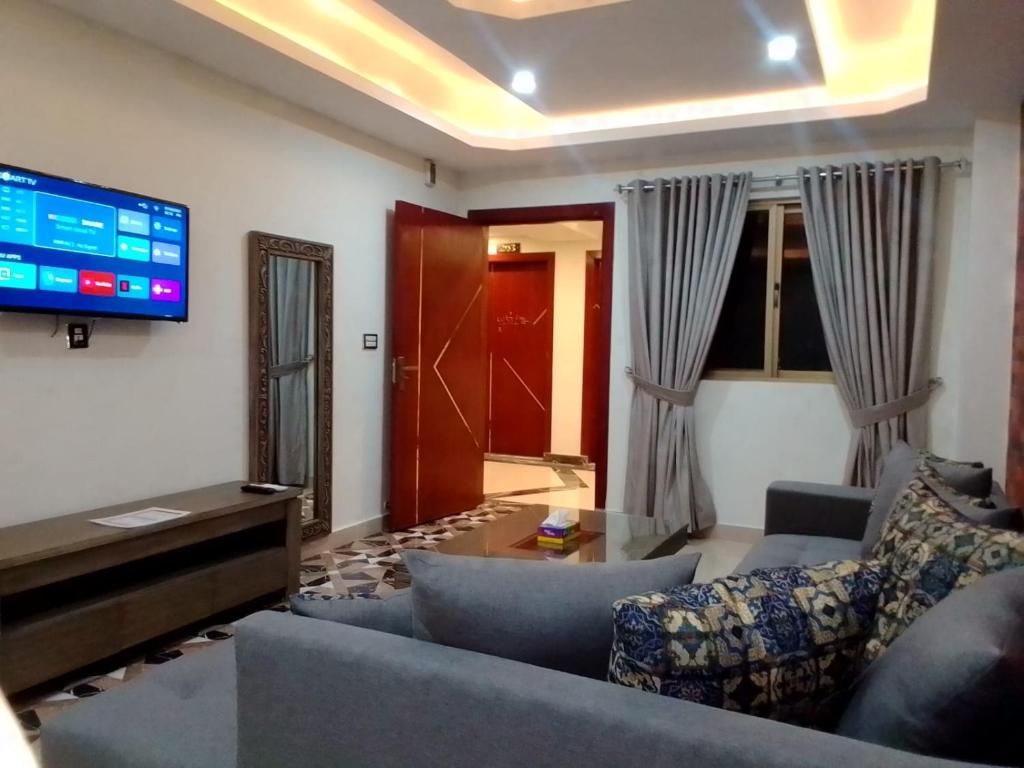 a living room with a couch and a tv at Royal Galaxy Hotel & Residence - Near Islamabad International Airport & Motorway in Islamabad