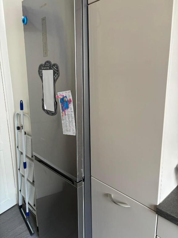 un réfrigérateur avec une note dessus dans une cuisine dans l'établissement Appartement cosy vue sur la Seine, à Boulogne-Billancourt