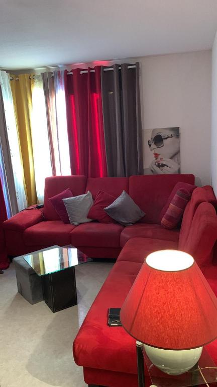 un salon avec un canapé rouge et une table dans l'établissement Visa pour l image Wellcome la famille et les enfants, à Perpignan