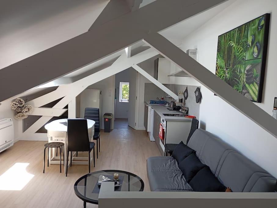 un salon avec un canapé et une table dans l'établissement Appartement loft 55m2 climatisé, à Courtemanche